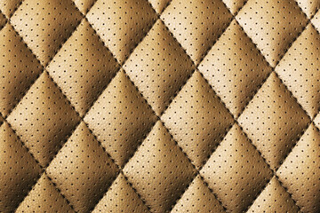 Brown quilted leather texture with perforated surface. Diamond pattern close-up of stitched...