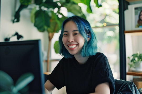 Happy blasian woman in creative remote job on video call – flexible work culture and diverse team collaboration, lesbian with blue hair	