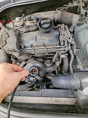Fototapeta premium DIY oil change of a personal diesel vehicle using a pump device in a garage setting.