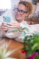 Mature woman using her smartphone at home in various situations. From socializing and working to...