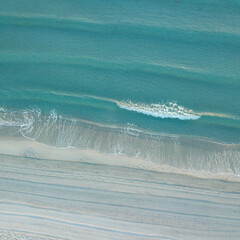 Image taken from above of summer beach and clear blue and turquoise sea