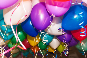 Colorful helium balloons hanging during indoor festive celebration event