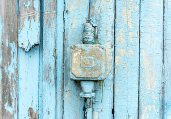 Old electrical installation on a blue wooden wall, outdated