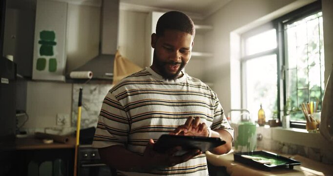 Paint, kitchen and man on tablet in home for inspiration, renovation ideas and planning. Interior design, remodeling and African person on digital tech for DIY, creative project and decor website