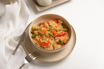 Quinoa vegetable salad on white wooden table. Vegetarian and diet food