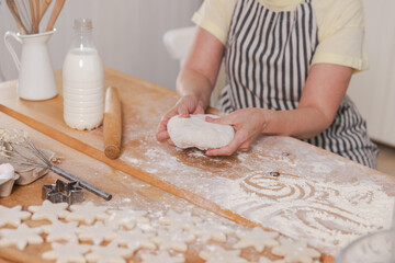 Senior woman cooking in kitchen, hands close up. Older mature lady grandmother hands knead dough bake cookies. Old grandma cook homemade food. Household housewife housework concept