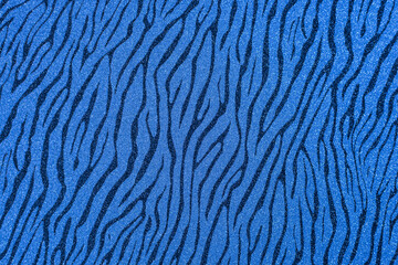 Texture of colored paper. Decorative sheet of cardboard with a zebra pattern. Blue shiny background.