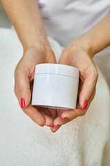 Jar of spa cream in the hands of a girl. Skin care. Medical and dermatological cosmetics for hands....