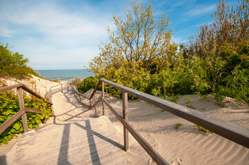 Wooden stair at dunes leading  to the sand beach
