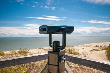 Observation deck with fixed observation binoculars. View on a sand dune and seashore