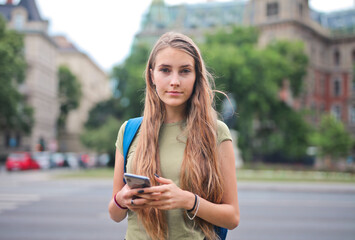 young woman uses a smartphone in the street