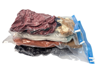 Stack of vacuum sealed clothes in plastic bag with blue zipper closure isolated on transparent background
