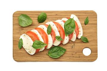 Mozzarella cheese with green basil leaves and tomato on cutting board isolated on white background