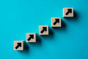 Growth concept with arrow cubes on blue background for business success and career development idea