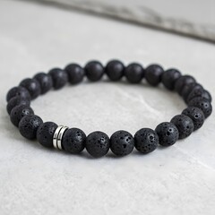 Black Lava Stone Aromatherapy Bracelet. Features porous volcanic rock and silver spacers. Ideal for diffusing essential oils on the go.