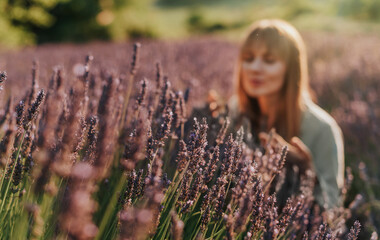 Woman Inhaling Scent of Flowers in Lavender Field