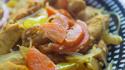 Carrots lying on a piece of meat in a dish close up