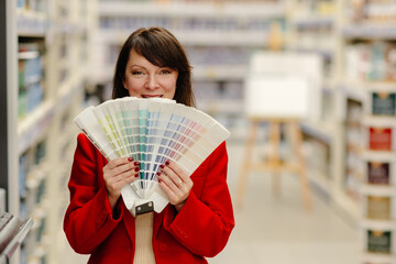 Interior designer choosing paint color from swatches in hardware store