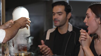 Cropped hand bartender serving mist smoky classical mixing whiskey with liquor of cocktail...