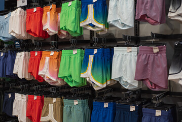 Vibrant array of female athletic, stride high-rise shorts displayed in sporty retail setting,...