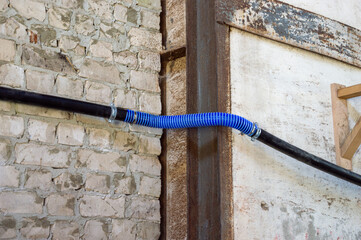 Two hoses are interconnected at a construction site, highlighting ongoing repair work against a...
