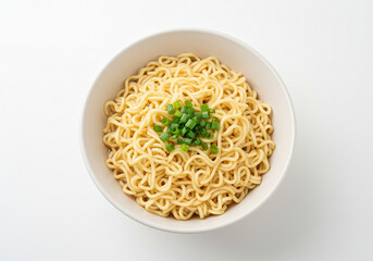 A top down view of a white bowl filled with noodles and topped with chopped green onions on white
