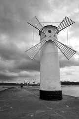 breakwater with a navigation sign in the shape of a windmill on the Baltic Sea in the city of Swinoujscie
