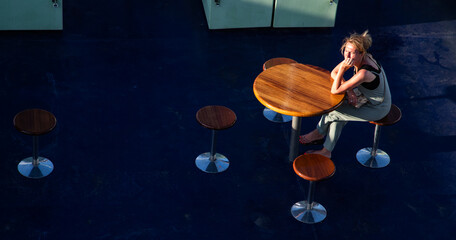top view of single pensive woman sitting at table