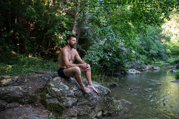 Fototapeta premium man sunbathing by the river