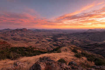 Fototapeta premium breathtaking summer sunset over expansive desert landscape showcases rich hues of orange pink and purple as sun