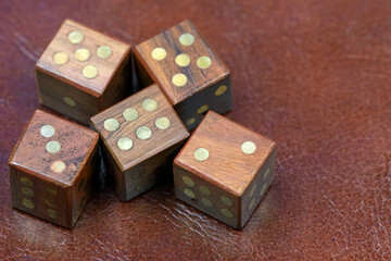 Five wooden dice on a leather surface
