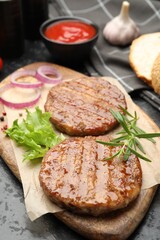 Delicious hamburger patties and spices on black table, closeup