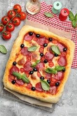 Tasty homemade pizza and ingredients on grey table, flat lay