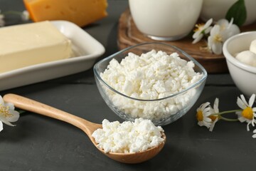 Fresh dairy products and flowers on grey wooden table, closeup