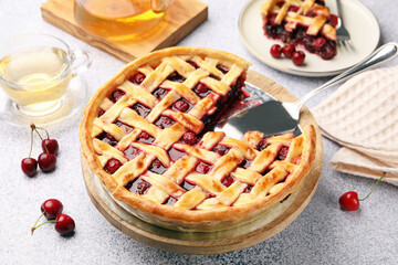 Tasty cherry pie and berries on grey textured table, closeup
