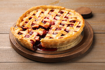 Tasty cut cherry pie on wooden table, closeup