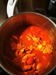 Delicious chicken curry simmering in a pot, blending spices and flavors in a home kitchen