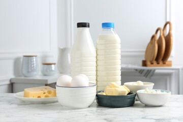 Different dairy products and eggs on white marble table indoors