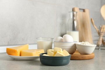 Different dairy products and eggs on gray textured table in kitchen