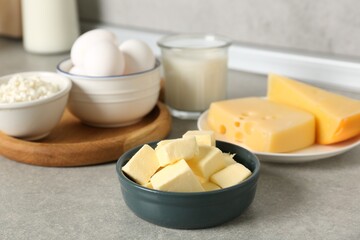 Different dairy products and eggs on gray textured table in kitchen, closeup
