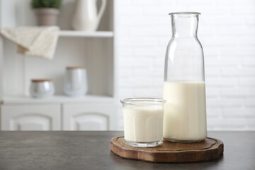 Dairy products. Fresh milk in glass and bottle on gray textured table indoors. Space for text