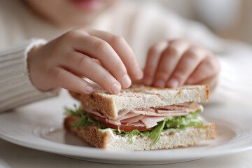 child hands making sandwich with ham, close up image about cooking