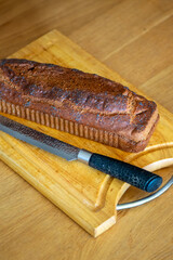 Homemade loaf of poppy seed bread on wooden cutting board