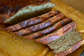 Homemade loaf of poppy seed bread on wooden cutting board