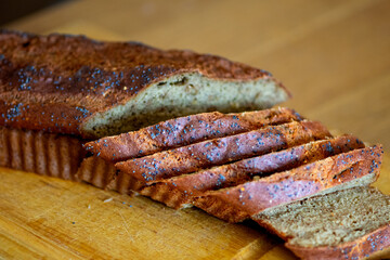 Homemade loaf of poppy seed bread on wooden cutting board