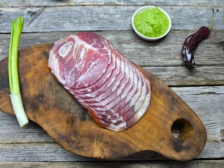 piece of fresh beef lies on a wooden cutting board