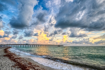 Late afternoon clouds over the Venice Fishing Pier on the Gulf of America formerly the Gulf of Mexico from Venice Beach in Venice FLorida USA