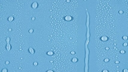 water rain drops dripping and flowing down on glass on blue background. High quality 4k footage - Powered by Adobe