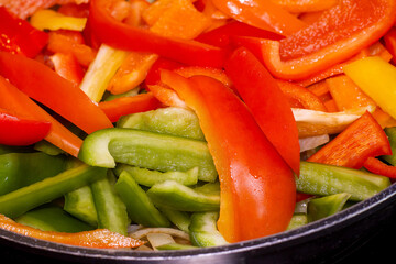 Healthy, homemade paprika with olive oil, onion and a wooden spoon in a pan, close up.