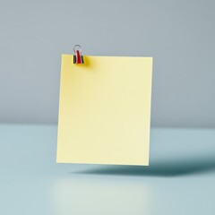 Yellow sticky note with paperclip on blue desk